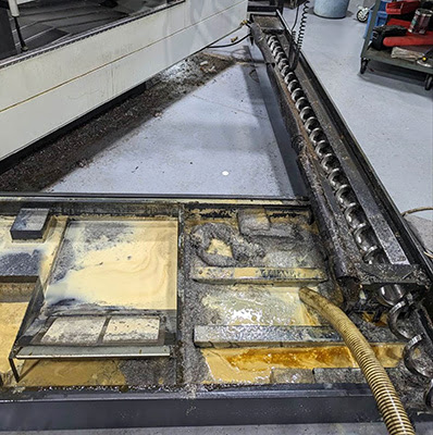 Removing old coolant and debries from the tank of CNC machine